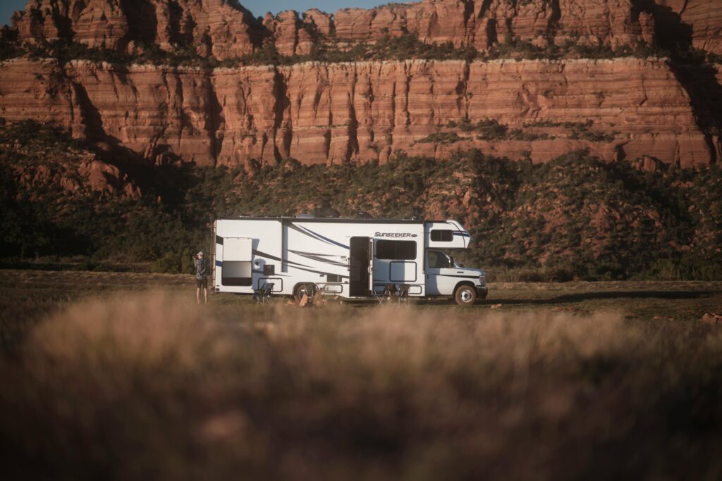 RV parked near Utah canyon under clear sky, perfect for adventure and travel enthusiasts.