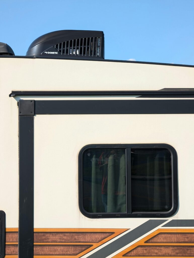 pexels-photo-28273511-28273511 Close-up of a modern RV exterior with an air conditioning unit, showcasing sleek design and functionality.