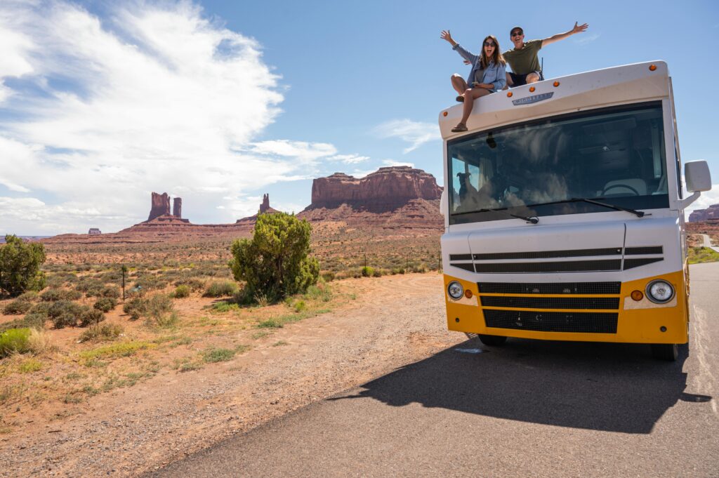 Couple enjoying a summer RV road trip in Monument Valley, Utah.